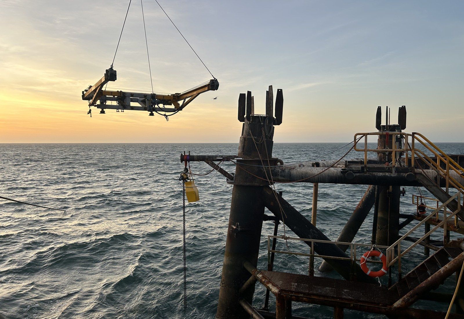A Blakemere lifting frame suspended over a platform at sunset during a recovery scope