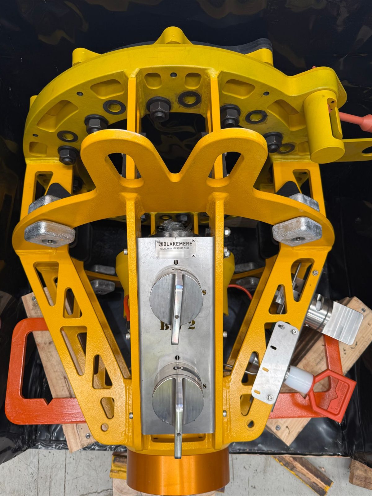 Blakemere Angel high pressure plug seen from above in its yellow ROV deployment frame, with two isolation valve handles on a stainless panel, orange lift handles and the orange plug body at the base