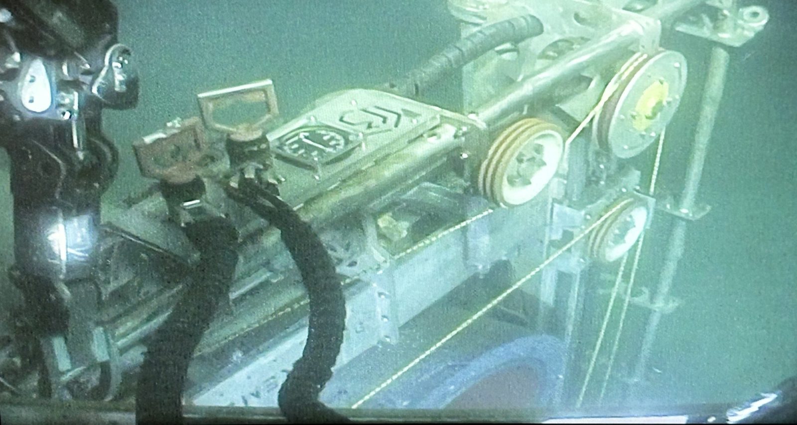 ROV camera view of a Blakemere diamond wire saw positioned on a subsea structure, the wire running over its sheaves