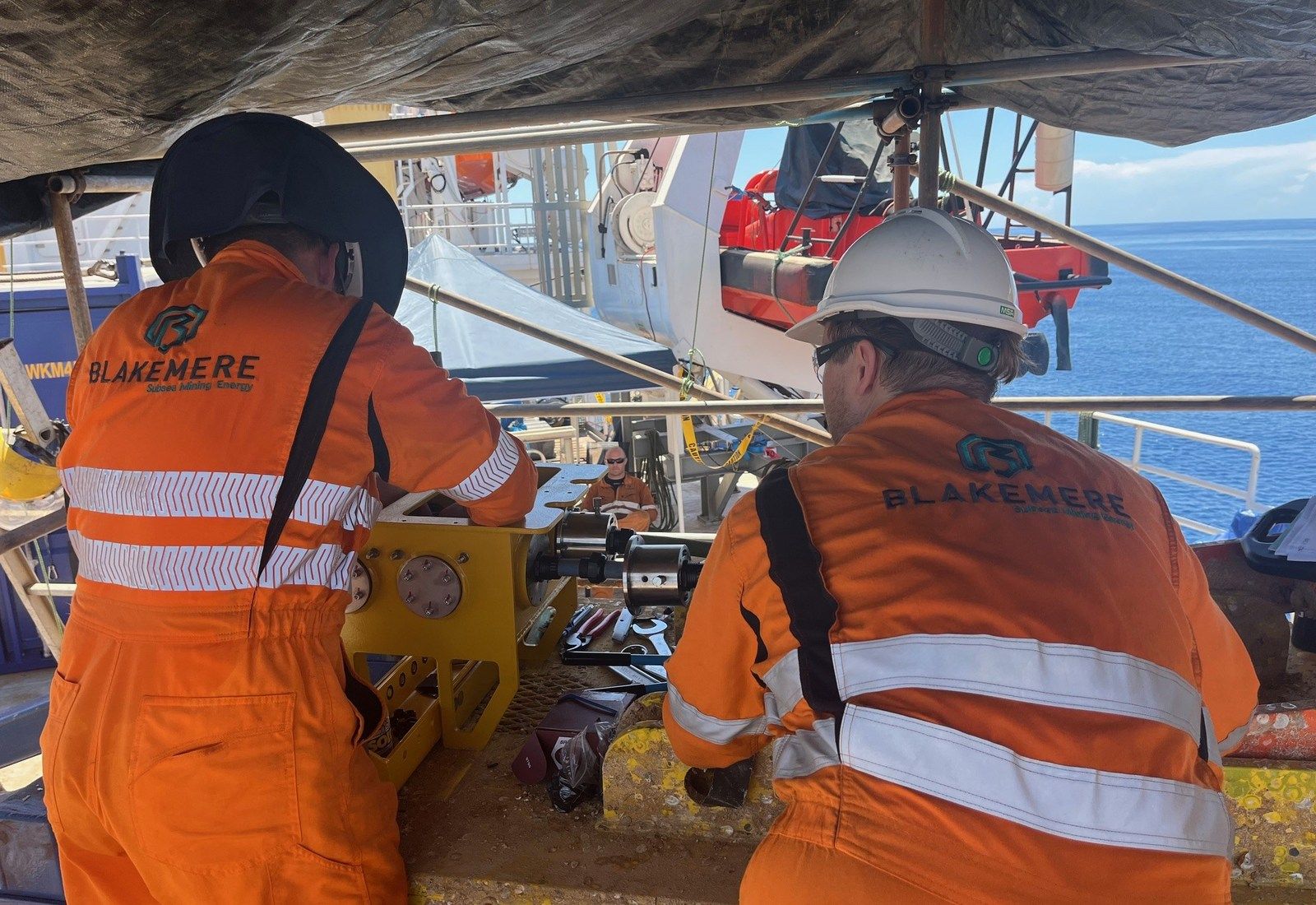 Two Blakemere technicians working on sealing components at a purpose-built tooling frame on deck