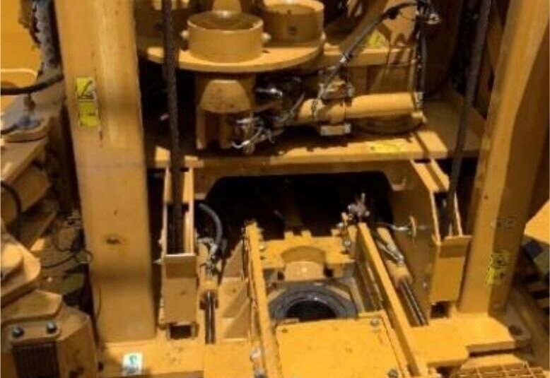 Drill floor looking down onto the torque reaction plate, with the mast and drill string above it