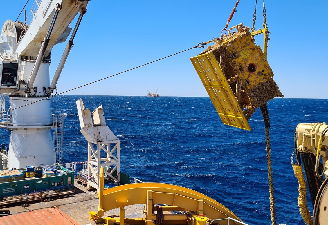 A recovered subsea structure lifted to the deck by vessel crane during a removal campaign
