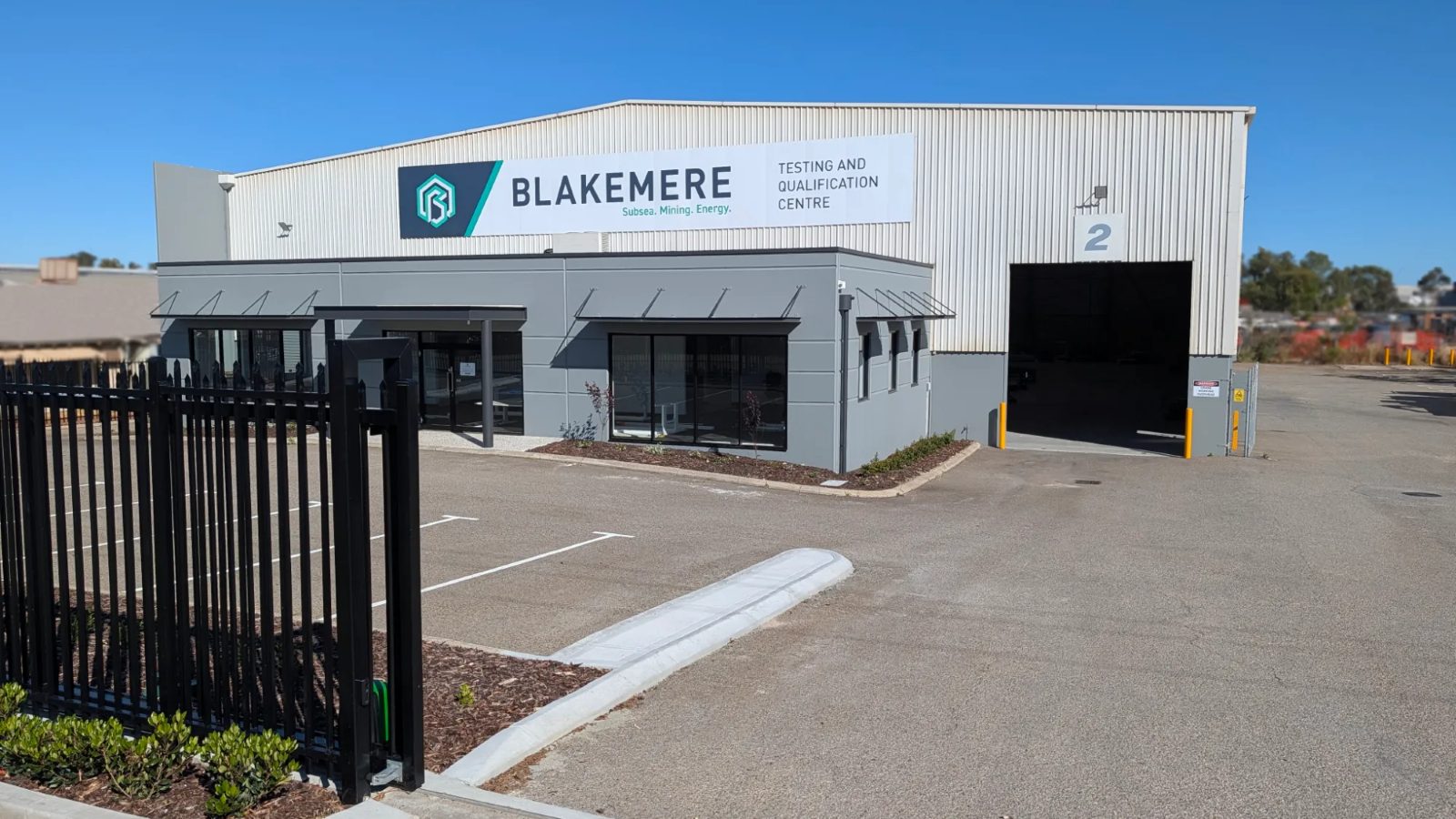 The Blakemere Testing and Qualification Centre in Welshpool, its office block and main bay door behind a secure gate